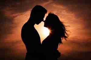 silhouetted image of couple embracing in front of sunset