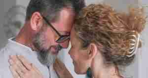 middle aged couple with foreheads together and smiling