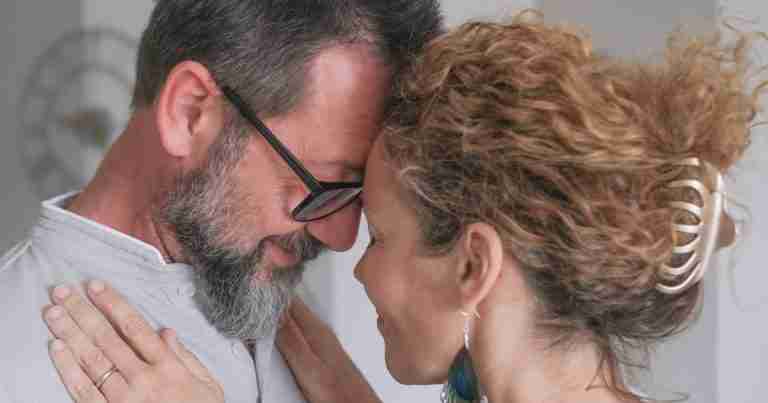 middle aged couple with foreheads together and smiling