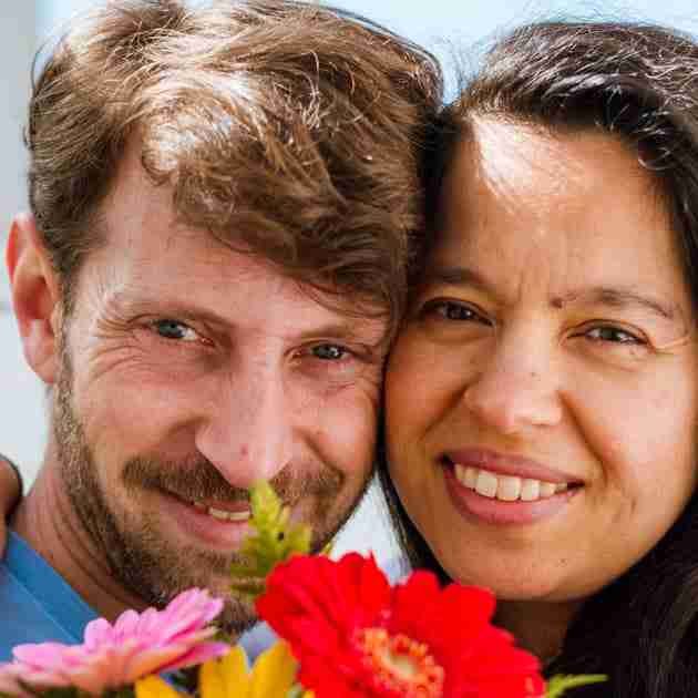 happy couple smiling and holding flowers