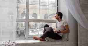 man thinking next to the window