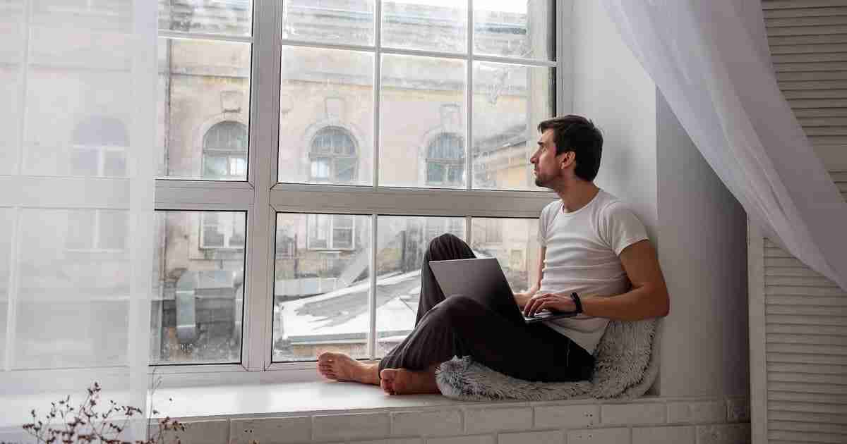man thinking next to the window