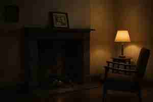 dark fireplace in front of an empty armchair