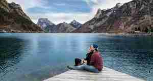 couple sitting on a boat dock holding each other