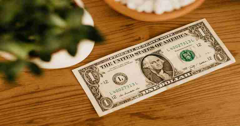 a dollar bill on a table; money