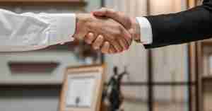 woman shaking hands with an attorney in a deal