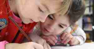 2 young boys working on something together