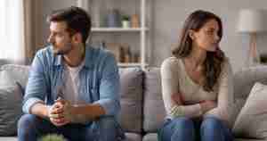 emotionally distant couple sitting on the sofa, looking away from each other
